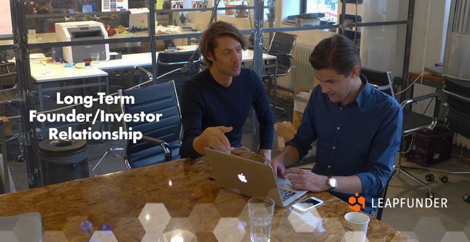 Two men discussing something while sitting at the office table