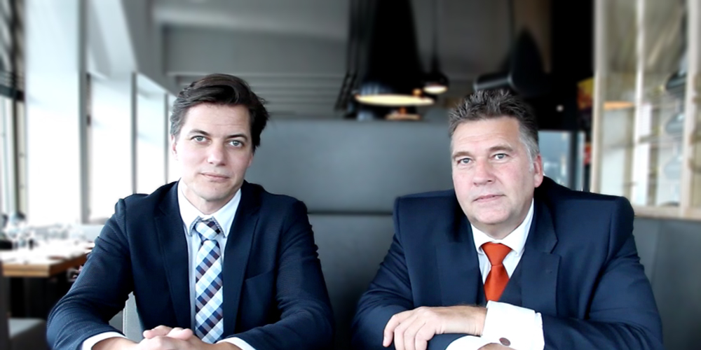 Two business men in suits sitting at the table