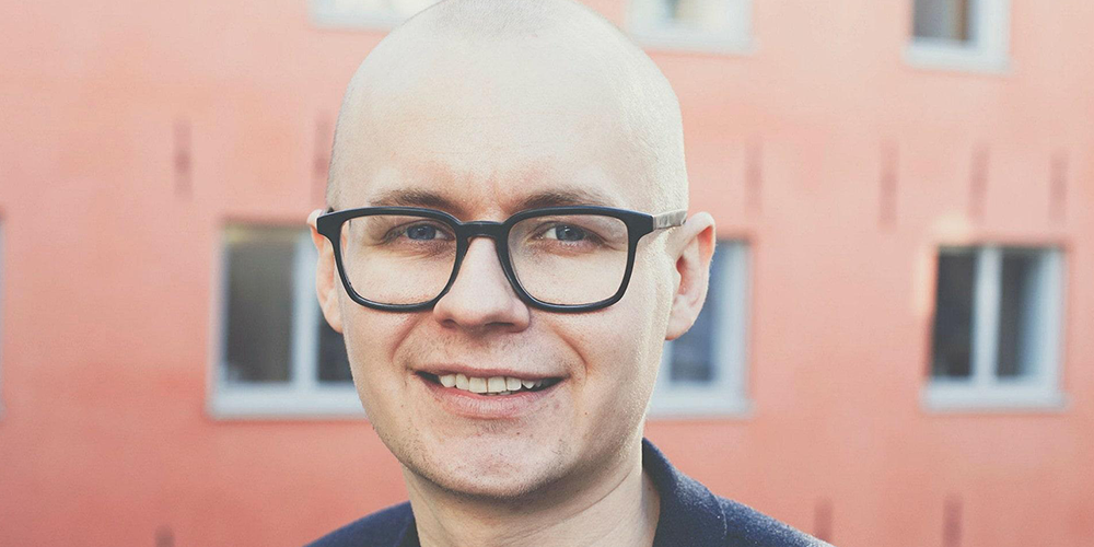A bald man with glasses posing for a profile photo