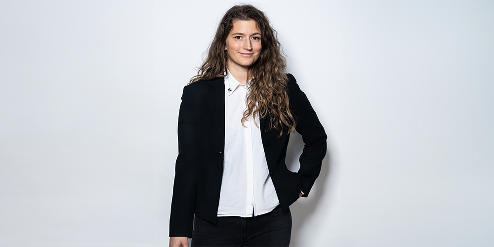 A caucasian woman with curly brown hair posing for a business photo